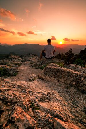Man on top of mountain. Conceptual scene on Hohe Wand in Austria during Sunsetの写真素材