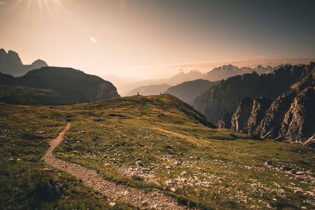 Mountains in morning sunrise light with sun flare in the dolomites italy during summerの写真素材