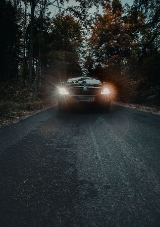 Car on the road in a autumn forest moodyの写真素材