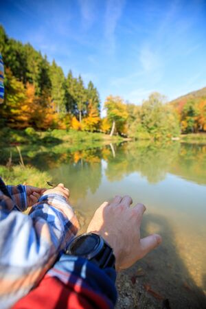 child boy at a autumn lake with a beautiful forest backgroundの写真素材