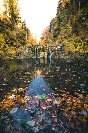 A beautiful wild waterfall flowing into a pool during autumn in oetschergraeben austriaの写真素材