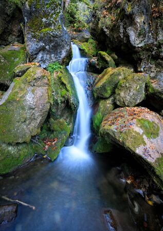 Wooden bridge over cascade falls over mossy rocks at Myrafalle, near Muggendorf in Lower Austriaの写真素材