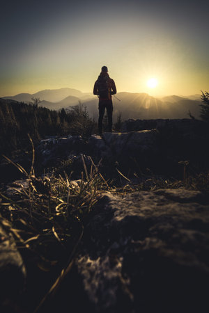 Man standing on Mountain Peak enjoying the Sunset in Springの写真素材