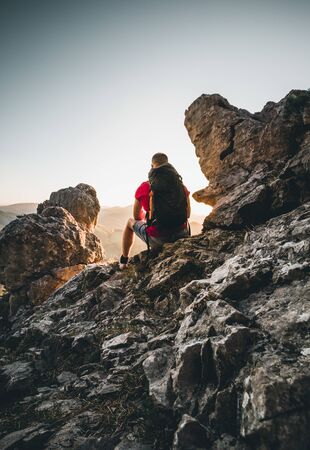 Man on top of mountain watching the sunset in the Alps of Austriaの写真素材