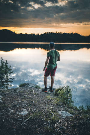 man stands on lake shore during sunriseの写真素材