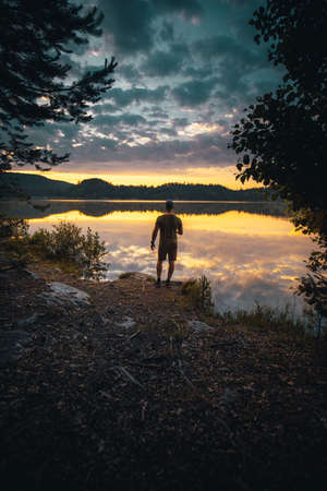 man stands on lake shore during sunriseの写真素材