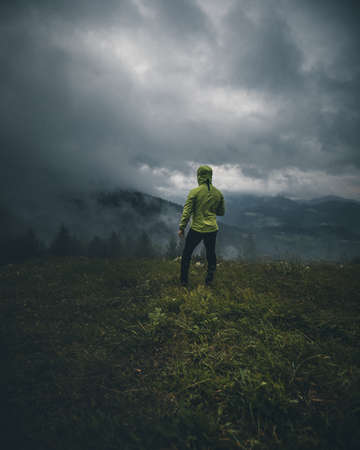 man alone in the moody forest on a foggy dayの写真素材