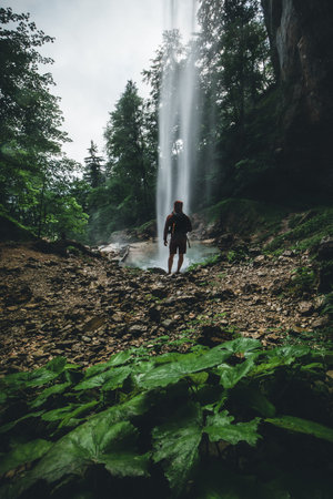 Man standing near big Waterfall in Austria in Summer