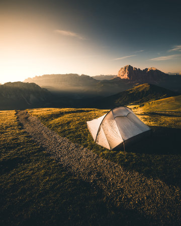 Tent in mountains at beautiful sunrise