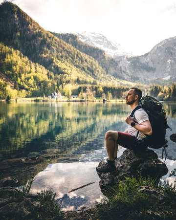 man relaxing at mountain lake langbathsee in salzkammergut during summerの写真素材