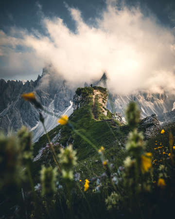 hiker on top of mountain in dolomites at cadini di misurina during sunset in summerの写真素材