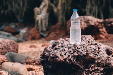 Bottle with mineral water in the nature among stones and grassの写真素材
