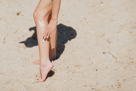 Beach body suntan skin care travel vacation. Bikini woman applying sunscreen lotion putting cream on...