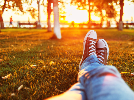 Close up of a man relaxing on a grass is sunset light.の写真素材