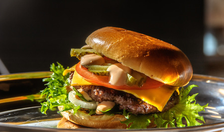Juicy tasty burger on a metal plateの写真素材