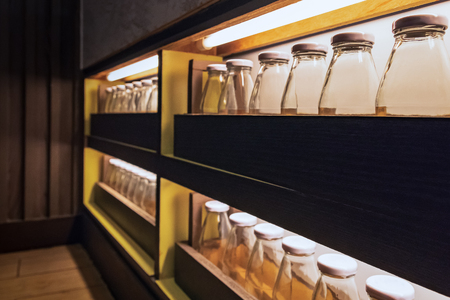 Glass bottles placed in layers. Underneath the neon lights at night.Clear after blurred.の写真素材
