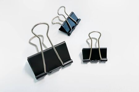 Many paper clips are placed on white paper.の写真素材