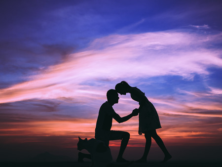 Silhouette of Happy Young Couple love Outside at Sunsetの写真素材