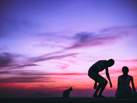 Silhouette of Happy Young Couple love Outside at Sunsetの写真素材