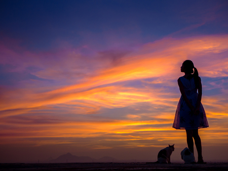 Silhouette of free woman enjoying freedom feeling happy at sunset. relaxing woman in pure happinessの写真素材