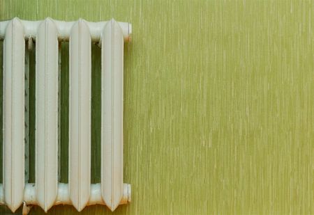 Retro heat radiator against the green wallの写真素材