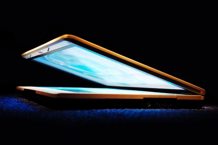 Half-closed gold laptop with blue bright screenの写真素材