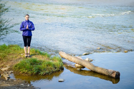 Young Beautiful Woman Meditate on the River. Active Lifestyleの写真素材