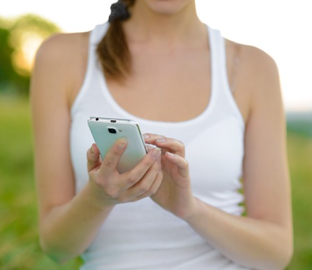 Woman Using her Mobile Smart Phone Outdoorsの写真素材