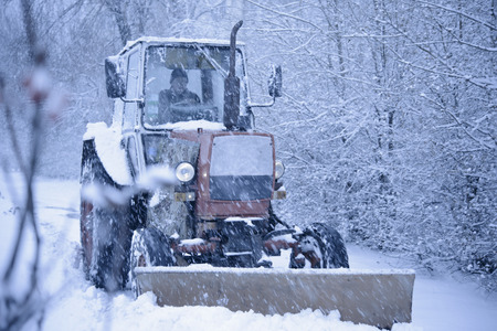 Tractor Cleaning Road from Snow in the Heawy Snowfall. Winterの写真素材