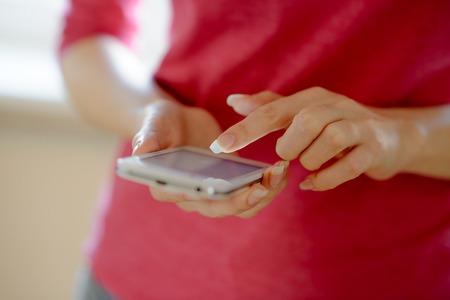 Woman Using Her Mobile Smart Phone at Home. Close-up of Mobile Phoneの写真素材