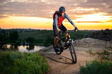Cyclist Riding the Bike on the Mountain Rocky Trail at Sunset. Extreme Sports