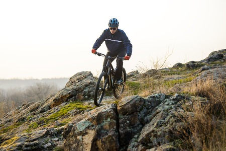 Enduro Cyclist Riding the Mountain Bike Down Beautiful Rocky Trail. Extreme Sport Concept. Free Space for Text.の写真素材