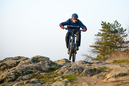 Enduro Cyclist Riding the Mountain Bike Down Beautiful Rocky Trail. Extreme Sport Concept. Free Space for Text.の写真素材