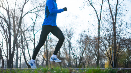 Young Sports Man Running in the Park in Cold Sunny Autumn Morning. Healthy Lifestyle and Sport...