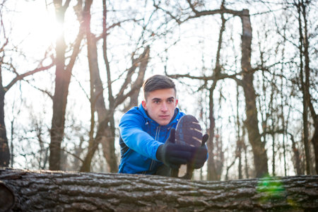 Young Male Runner Stretching in the Park in Cold Sunny Autumn Morning. Healthy Lifestyle and Sport...