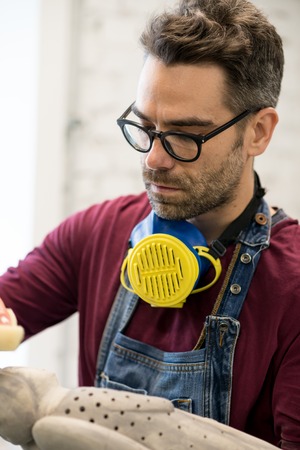 Portrait of Ceramist Dressed in an Apron Working on Clay Sculpture in Bright Ceramic Workshop.の写真素材