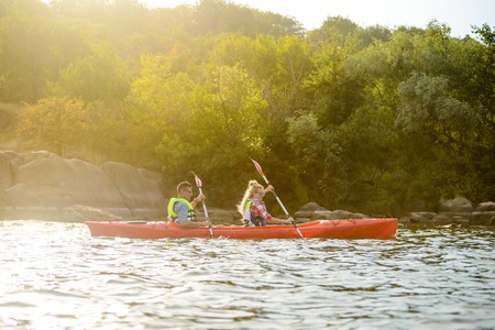 Young Happy Couple Paddling Kayak on the Beautiful River or Lakeの写真素材
