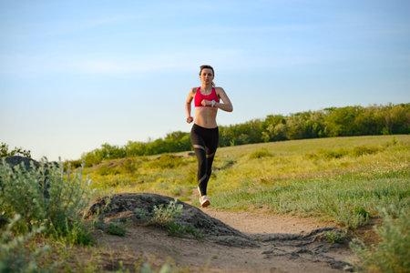 Young Beautiful Woman Running on the Mountain Trail in the Hot Summer Evening. Sport and Active...