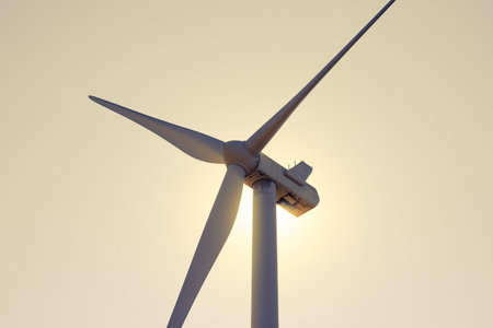 Wind Generator Turbine in Bright Sun Light on the Evening Sky Bacground. Green Renewable Energy...