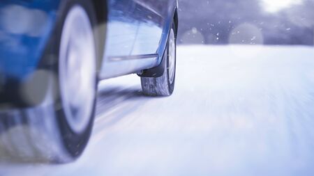 Blue Car Moving Fast on the Winter Snowy Roadの写真素材