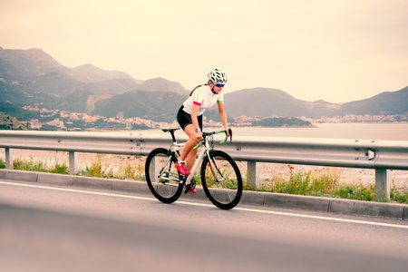 Young Woman Cyclist Riding Bike on the Mountain Road. Adventure, Healthy Lifestyle, Sport