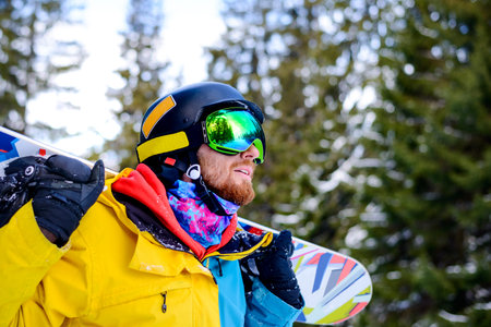 Portrait of Young Snowboarder with the Snowboard in the Winter Forest. Snowboarding and Winter Sportsの写真素材