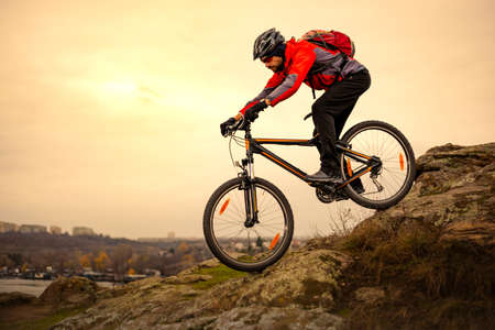 Cyclist Riding the Mountain Bike on the Rocky Trail at Cold Autumn Evening. Extreme Sport and Enduro Cycling Concept.の写真素材
