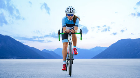 Young Woman Cyclist Riding Road Bike in the Beautiful Mountains. Adventure, Healthy Lifestyle, Sportの写真素材
