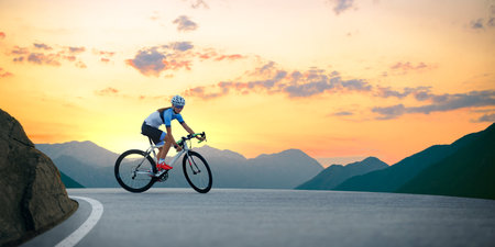 Woman Cyclist Riding Road Bike in the Beautiful Mountains at Sunset. Adventure, Healthy Lifestyle, Sportの写真素材
