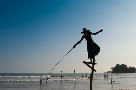 Silhouette of the traditional fisherman at the sunrise near Galle in Sri Lankaの写真素材