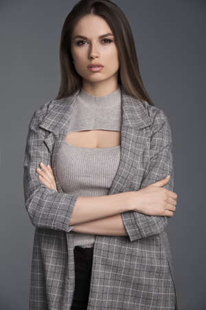a beautiful business woman crossed her arms , looks great in the studioの写真素材