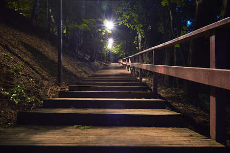 Wooden staircase in the woods at night. Lighting with lanternsの写真素材