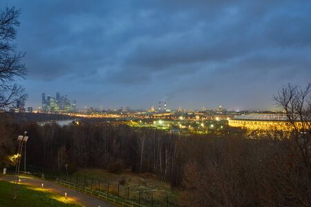 Cityscape of Moscow with skyscrapers and sports stadium at background and forest with river at foregroundの写真素材