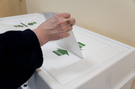 MOSCOW, RUSSIA - DECEMBER 4: Woman put election ballot with candidates of parties to the State Duma...
